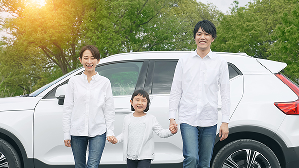 車の前に立つ家族